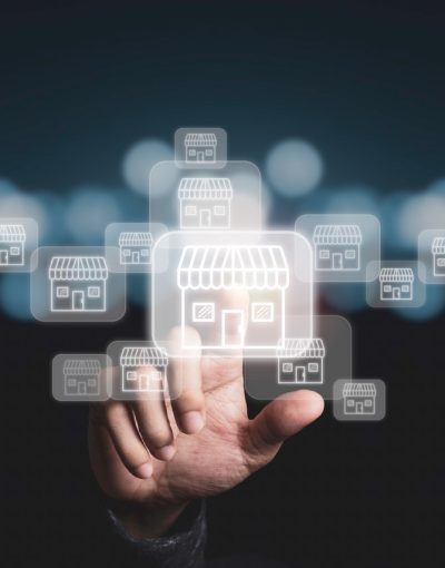 Businessman hand pointing to virtual shopping store which connection line with others small shopping stores , expand and development franchise concept.